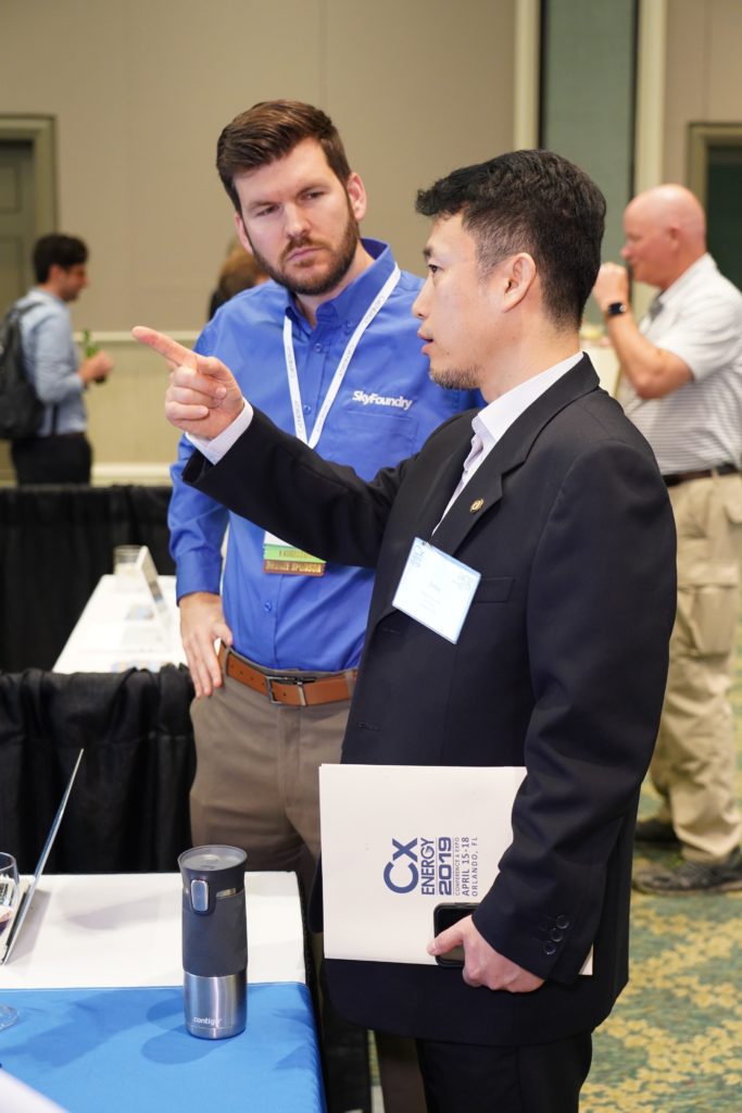 An attendee from CxEnergy is networking with exhibitor and associate member SkyFoundry.
